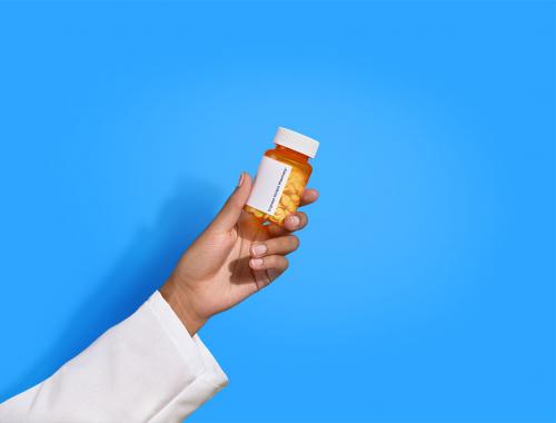 pharmacist hand holding pill bottle