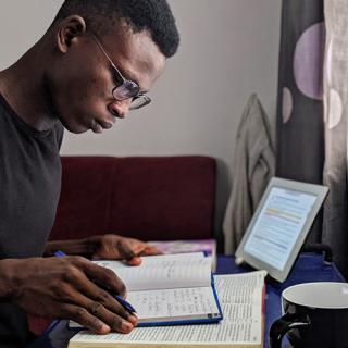 one man studying with books and computer