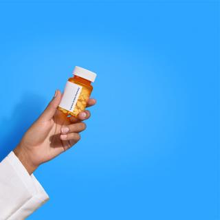 pharmacist hand holding pill bottle
