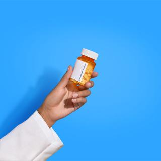 pharmacist hand holding pill bottle